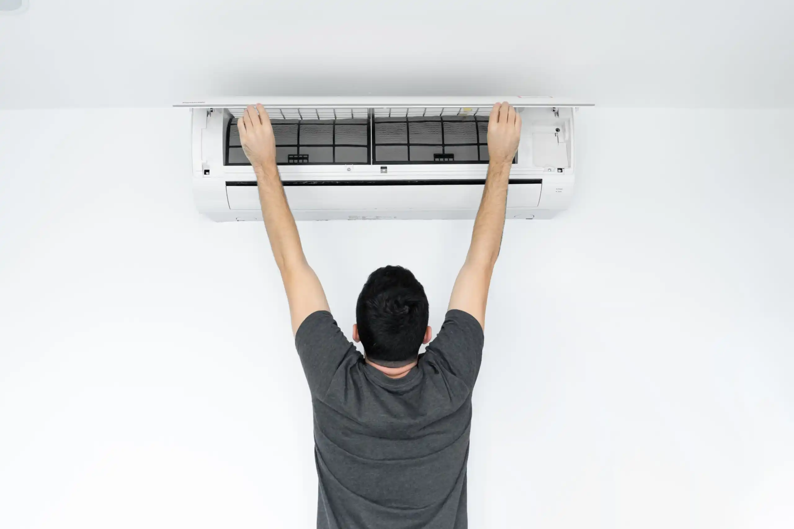 guy-cleans-filter-home-air-conditioner-from-dust-scaled-1